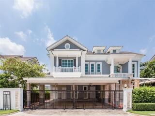 Front view of a modern two-story house with a gated driveway