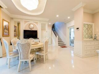 Elegant dining and living space with staircase