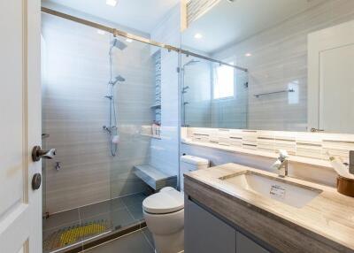 Modern bathroom with glass shower and wooden vanity