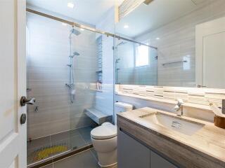 Modern bathroom with glass shower and wooden vanity