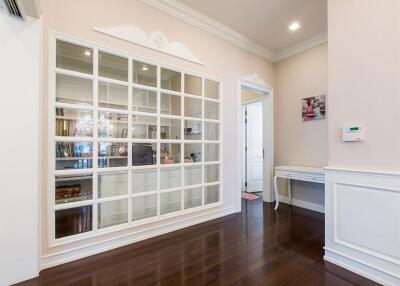 Well-lit room with large glass-pane window and dark wood flooring