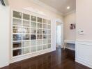 Well-lit room with large glass-pane window and dark wood flooring