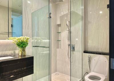 Modern bathroom with glass shower, vanity, and toilet