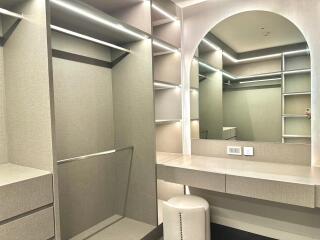 Modern walk-in closet with built-in shelving and dressing table