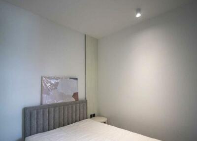 Minimalist bedroom with bed and wall light