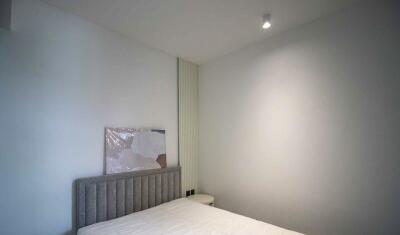 Minimalist bedroom with bed and wall light