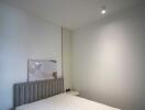 Minimalist bedroom with bed and wall light