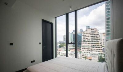 Modern bedroom with large windows and city view