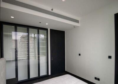 Modern bedroom with large window and dark wooden door