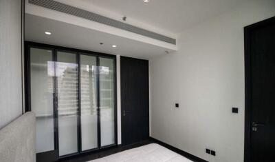 Modern bedroom with large window and dark wooden door