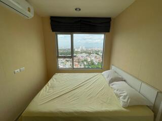 Bedroom with large window and city view