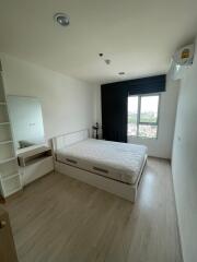 Bedroom with bed, window, and wall-mounted air conditioner