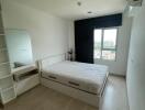 Bedroom with bed, window, and wall-mounted air conditioner