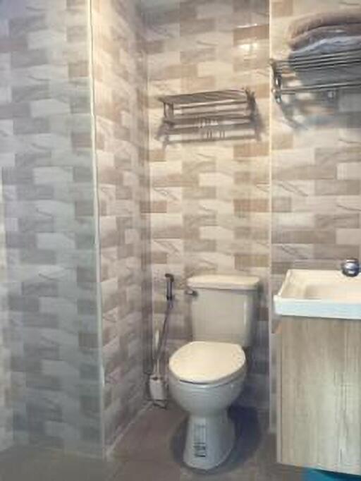 Bathroom with toilet, sink, and wall-mounted shelves