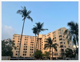 Exterior view of a multi-story residential building with palm trees