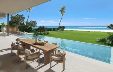 Outdoor patio with dining set and adjacent pool overlooking the ocean