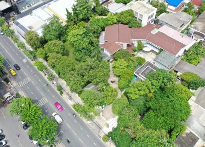 Aerial view of residential property with surrounding greenery and nearby streets