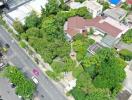 Aerial view of residential property with surrounding greenery and nearby streets