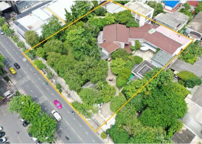 Aerial view of a property with surrounding greenery and buildings