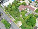 Aerial view of a property with surrounding greenery and buildings