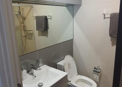 Modern bathroom with toilet, sink, and mirror