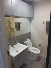 Modern bathroom with toilet, sink, and mirror