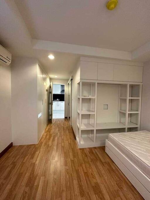 modern bedroom with wooden flooring and built-in shelves