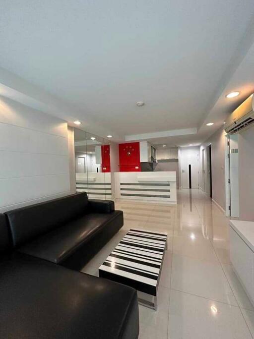 Modern living room with black leather sofa and striped coffee table