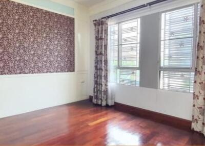 Bright bedroom with large windows and floral curtains