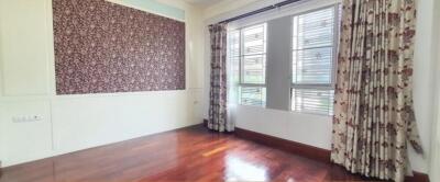 Bright bedroom with large windows and floral curtains