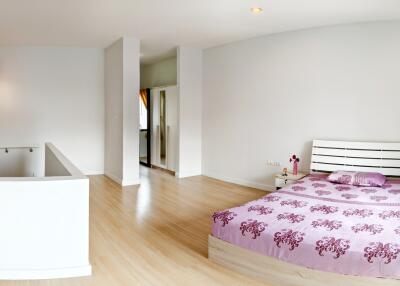 Spacious bedroom with wooden flooring and modern decor