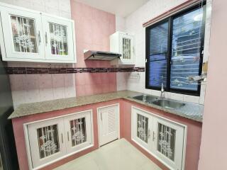 Modern compact kitchen with white and pink design