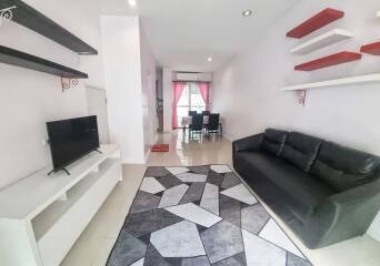 Modern living room with black sofa and wall-mounted shelves