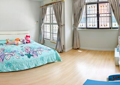 Bright and cheerful bedroom with a large window and colorful bedding