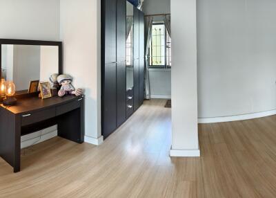 Bedroom with a vanity desk, wardrobe, and wooden floor