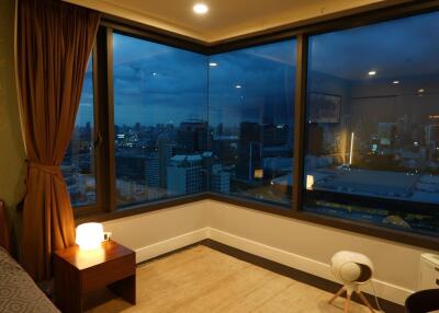 Bedroom with large windows and night city view