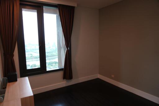 Bedroom with large window and wooden floor