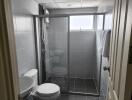 Modern bathroom with gray tiling and glass-enclosed shower