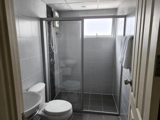 Modern bathroom with gray tiling and glass-enclosed shower