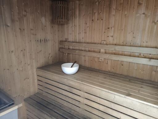 Wooden sauna with a bowl and ladle