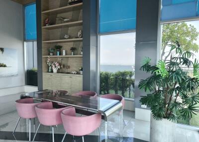 Modern dining area with glass table and pink chairs