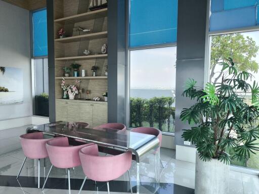 Modern dining area with glass table and pink chairs