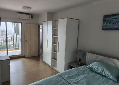 Spacious bedroom with wardrobe, balcony access, and air conditioning