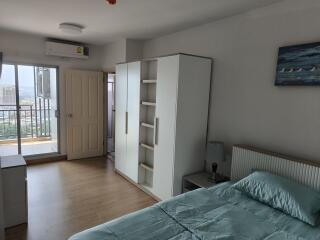 Spacious bedroom with wardrobe, balcony access, and air conditioning