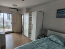 Spacious bedroom with wardrobe, balcony access, and air conditioning