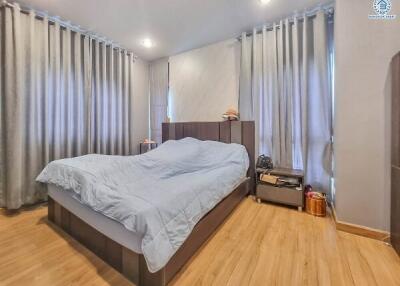 Spacious bedroom with wooden flooring and modern furnishings