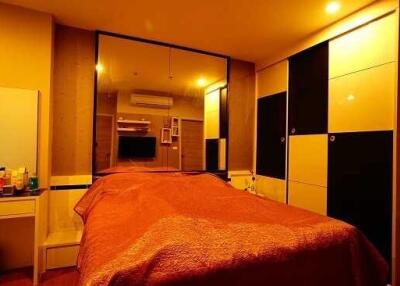 Spacious bedroom with a large bed, mirror, and wardrobe
