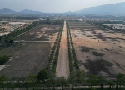 Aerial view of large swathes of undeveloped land with mountains in the background