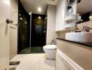 Modern bathroom with glass shower, toilet, and sink