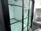 Glass-enclosed utility room with washing machine and skylight